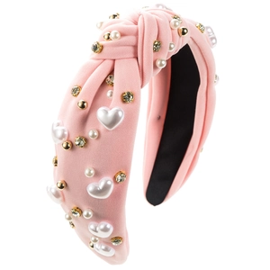 Detailed view of pink knotted headband with rhinestones, pearls and heart beads decoration
