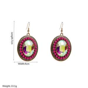 Detailed view of oversized bohemian bronze earrings with pink beads and turquoise stones