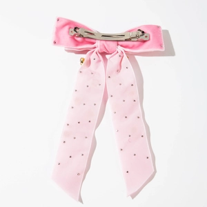 Détail d'une pince à cheveux nœud en velours rose avec strass cœur et ruban