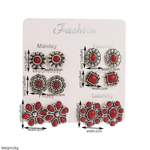 Detail van boho zilveren oorbellen set met rode harsstenen en gegraveerde bloemmotieven