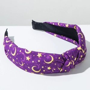 Close-up of purple fabric headband with yellow star and moon print and knot detail