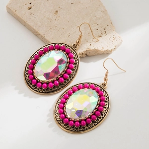 Detail of bohemian turquoise drop earrings with vibrant pink beads and antique gold texture