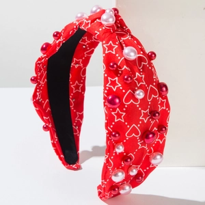 Détail du serre-tête noué rouge avec motifs de cœurs et perles fantaisie