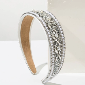 Close-up of wide baroque headband with white pearls and sparkling crystal flower patterns