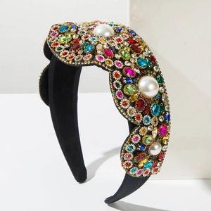 Detail shot of Baroque padded headband with colorful rhinestones and large pearls on black velvet