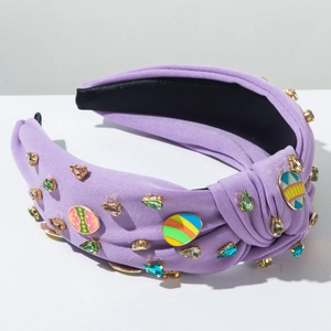 Détail du serre-tête violet à nœud avec strass colorés et breloques en forme d'œuf de Pâques