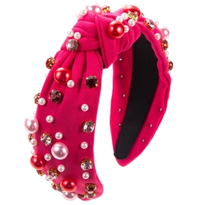 Luxurious fuchsia knotted headband with pearls and rhinestones on a white background