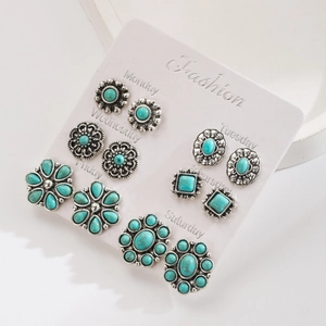Detail van westerse turquoise oorbellen set met vintage bloemen en geometrische vormen