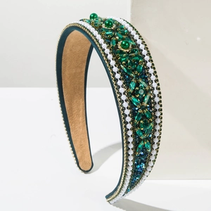 Close-up of luxury emerald green crystal and white pearl embellishments on wide headband