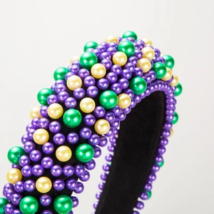 Détail macro du serre-tête épais Mardi Gras orné de perles violettes, vertes et dorées