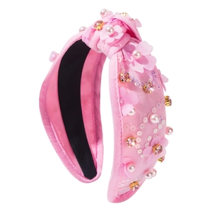 Serre-tête en tissu rose orné de fleurs 3D, paillettes, perles et strass sur fond blanc