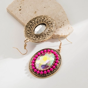 Macro view of Bohemian drop earrings showing intricate gold metal texture and gemstones