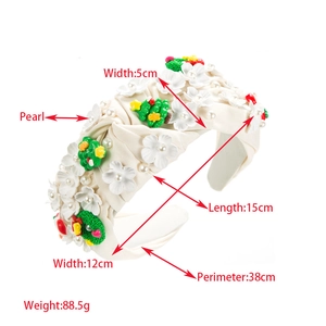 Détail d'un serre-tête large en tissu avec fleurs 3D, sapins de Noël et perles