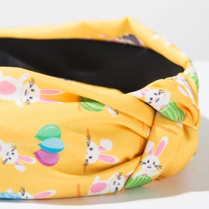 Detail view of Easter knotted headband featuring yellow fabric and bunny carrot prints