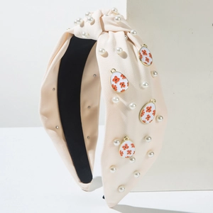 Detailaufnahme des Knotenstirnbands mit Kunstperlen und Blumen-Osterei-Anhängern
