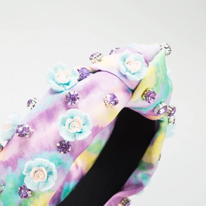 Détail du serre-tête tie-dye avec roses 3D et cristaux violets étincelants décor