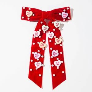 Detail van rode fluwelen harik met parels en Hug Me hartjes op een witte achtergrond