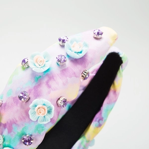 Détail d'un serre-tête noué tie-dye avec roses en tissu et strass scintillants