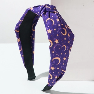Knotted fabric headband featuring celestial star and moon prints in a deep purple hue