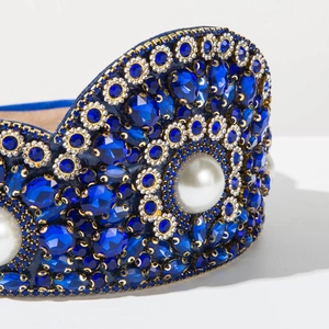Close-up of Baroque headband with blue crystals, gold chains and white pearls