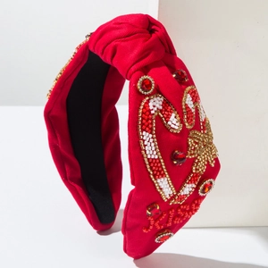 Détail du bandeau rouge perlé avec lettrage Xmas, strass et motifs de canne à sucre