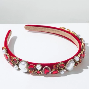 Détail macro du serre-tête en velours rouge avec rubis, perles et métal doré