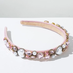 Détail d'un serre-tête en velours rose avec perles en cœur et cristaux