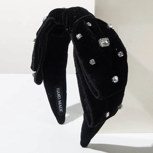 Dettaglio del cerchietto in velluto nero fatto a mano con strass lucidi e etichetta