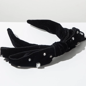 Dettaglio macro del cerchietto in velluto nero con design a nodo e strass brillanti