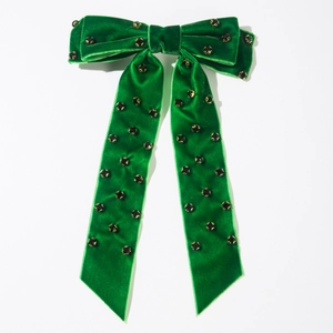 Détail de la barrette à nœud en velours vert foncé avec strass et rubans longs