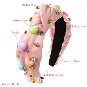 Détails du serre-tête en tissu rose avec cœurs en résine macaron et strass brillants