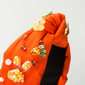 Detail of orange fabric headband featuring crystal bunny and carrot embellishments