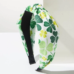 Detailed close-up of St. Patrick's Day headband with green shamrock patterns and top knot