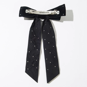 Détail de la pince en métal argenté et du ruban en velours noir sur cette barrette à cheveux