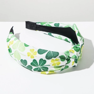 Detail of St. Patrick's Day headband with green and yellow clover patterns and top knot
