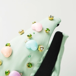 Détail des cœurs 3D colorés et des strass étincelants sur le serre-tête vert clair