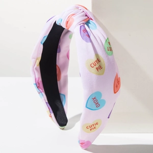 Detail of pink knotted headband with heart prints and sweet HUG ME text designs