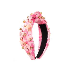 Détail du serre-tête imprimé léopard rose avec strass et décoration de nœud élégante