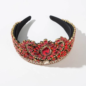 Macro detail of Baroque gold tiara with red pear-cut gems and white rhinestones