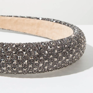 Detailed close-up of a wide padded headband featuring sparkling dark grey rhinestones