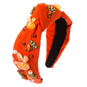 Detail of orange knot headband featuring Easter bunny patches and carrot crystals