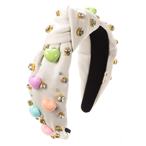 Détail de serre-tête large crème avec cœurs en résine colorés et strass scintillants