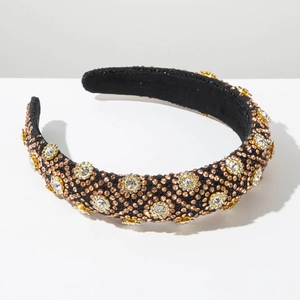 Gros plan détaillé d'un serre-tête baroque avec des fleurs en strass et des perles de bronze
