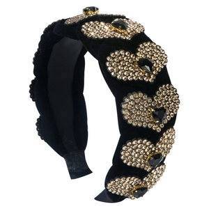 Elegante cerchietto in velluto nero con strass a cuore e cristalli su sfondo bianco neutro