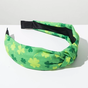 Detail of St. Patrick's Day headband with green shamrock pattern and top knot design