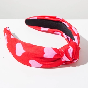 Detail of red headband with pink heart patterns and stylish knotted top design