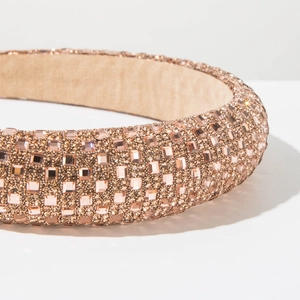 Close-up of champagne rhinestones and velvet lining on a baroque style headband