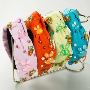 Colorful knotted headbands with crystal rabbits and carrots on a gold display stand