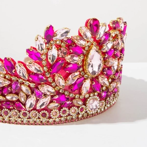 Macro detail of luxury baroque tiara with magenta and pink rhinestones in gold setting