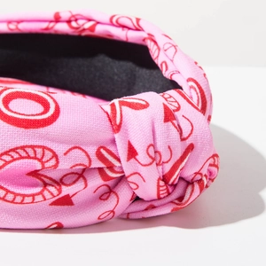 Detail of pink heart-printed knotted headband with premium fabric texture and anti-slip lining